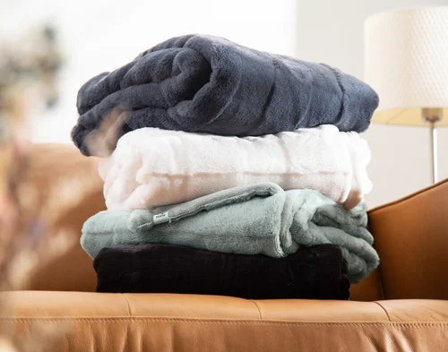 All of our Etched Check Throws piled on a couch.