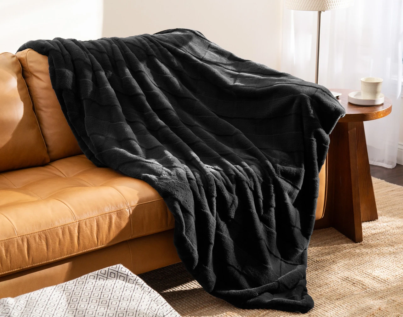 Our Etched Check Throw - Black Ink draped on a brown couch.