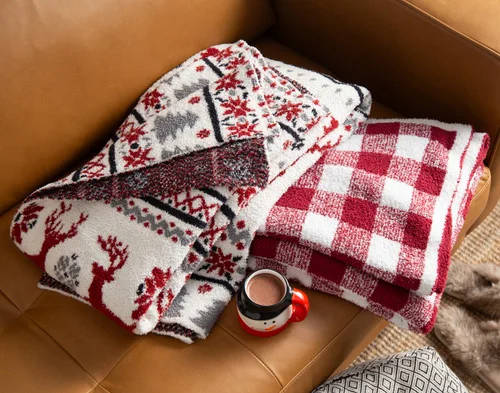 Our Chenille Jacquard Throws folded on a brown couch.