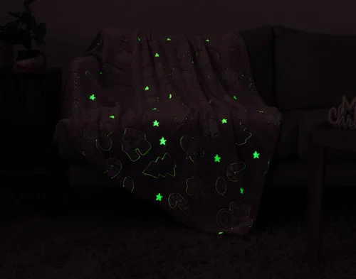 Dark view of our Holiday Huddle Glow in the Dark Throw showing its green-outlined designs.