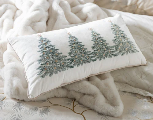Our Deck the Pines Holiday Boudoir Cushion on a bed with other accessories.