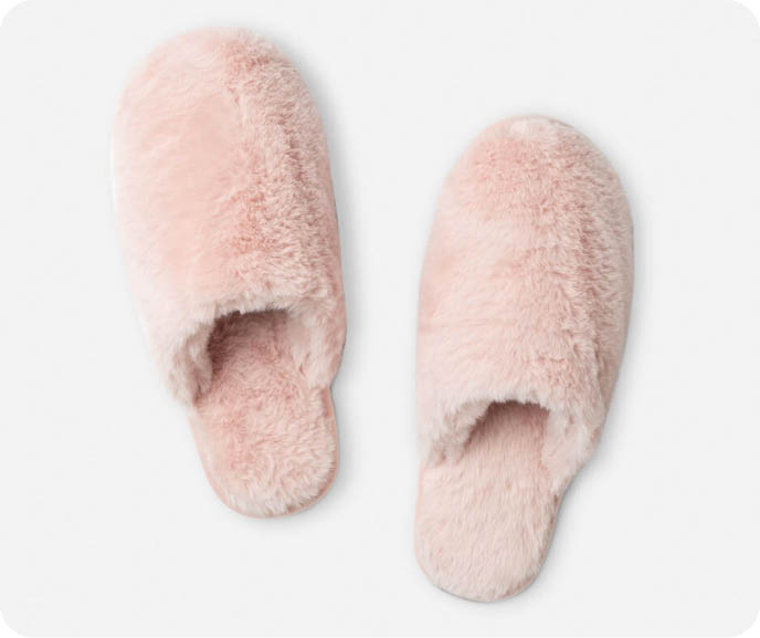 Our Plush Faux Fur Slippers in Blush are pale pink and feature a furry textured surface.
