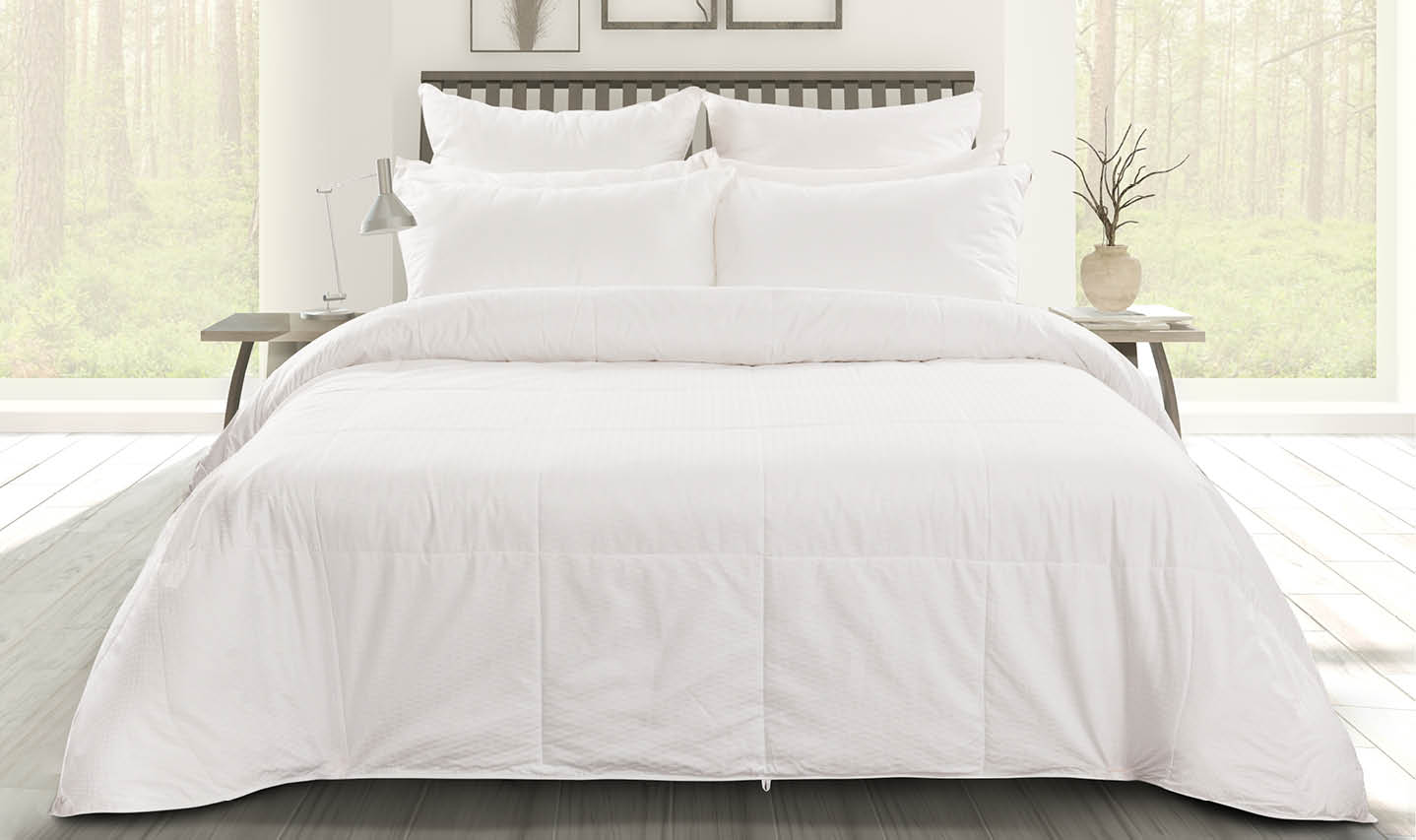 Front view of a silk-filled duvet laying softly over a queen bed in a white bedroom. Front view of a silk-filled duvet laying softly over a queen bed in a white bedroom.