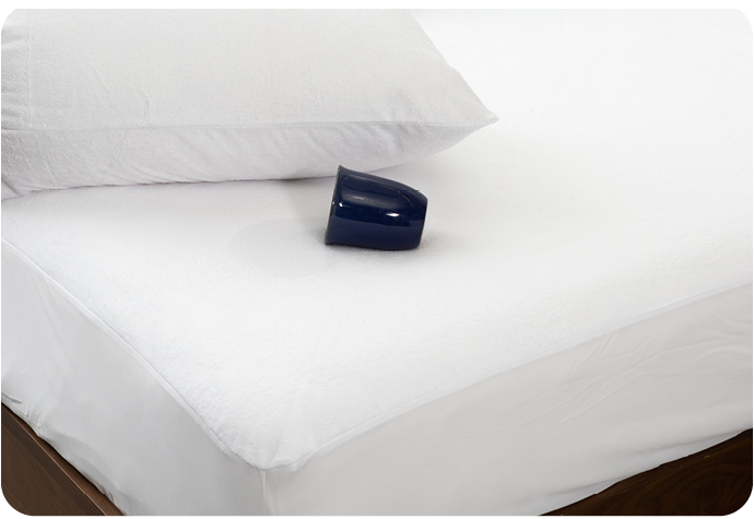 Dark blue mug lying horizontally on its side on a white mattress with mattress protector