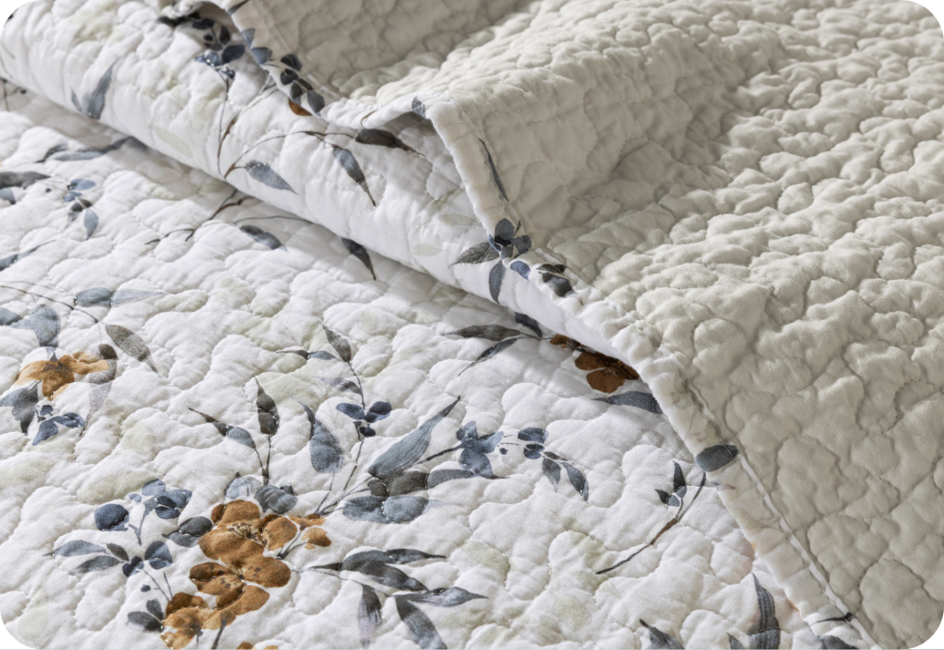A folded flowered quilt.