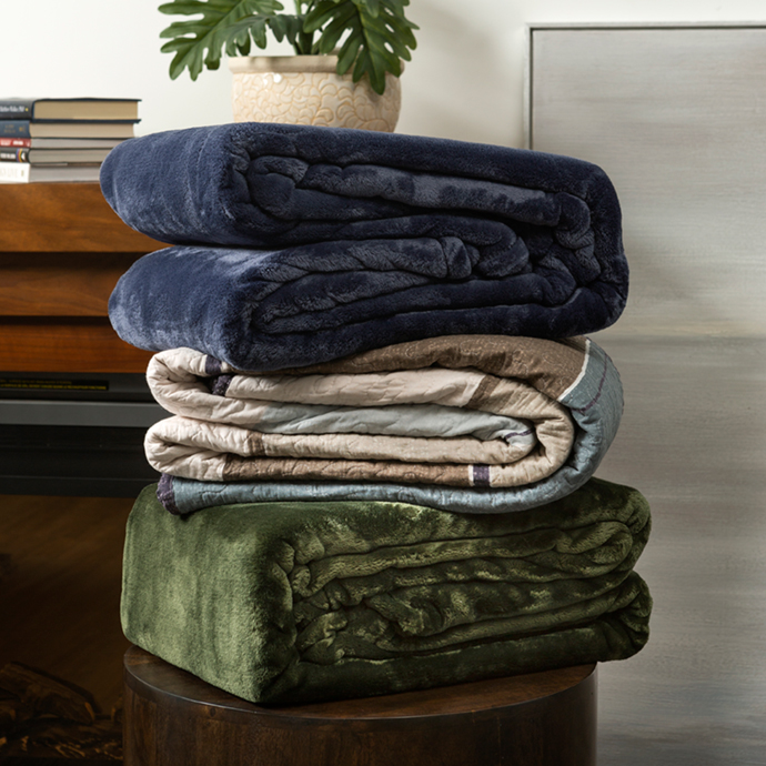 Blankets and Quilts piled together on shelf