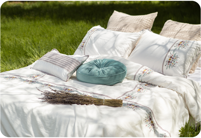 An elegant white bed laying on the grass during a very warm sunny day.