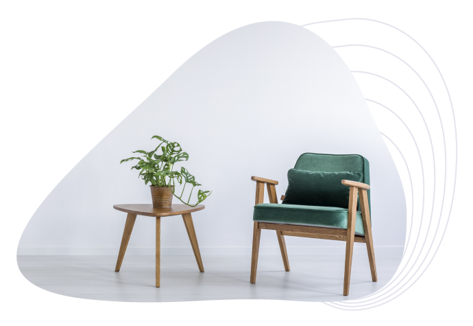 An empty chair and houseplant on a stool in a blank and empty room.