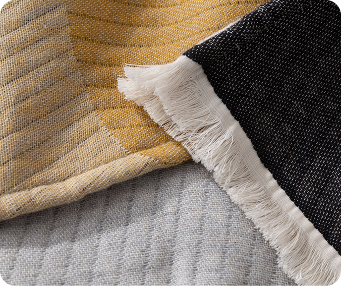 Close up of the ribbed Estrela throw blanket with its fringed edges. Close up of the ribbed Estrela throw blanket with its fringed edges.