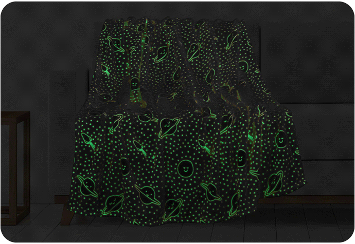 A GIF of our Happy Planet Glow in the Dark Fleece Throw draped on a couch shown in both light and dark settings.