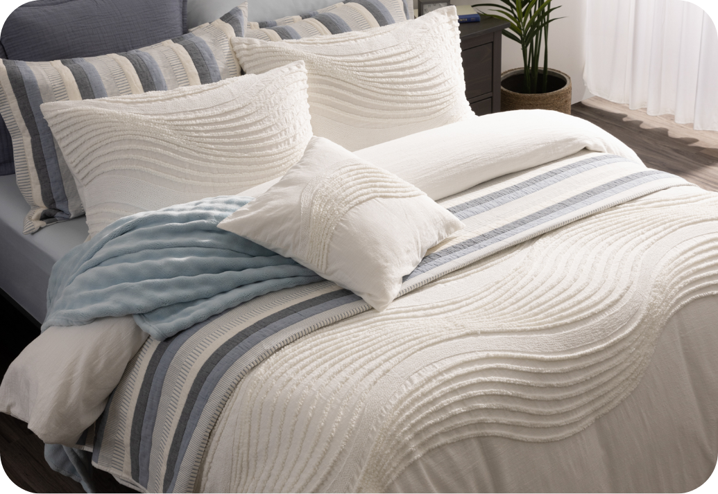 A QE Home quilt set decorating the head of a bed.