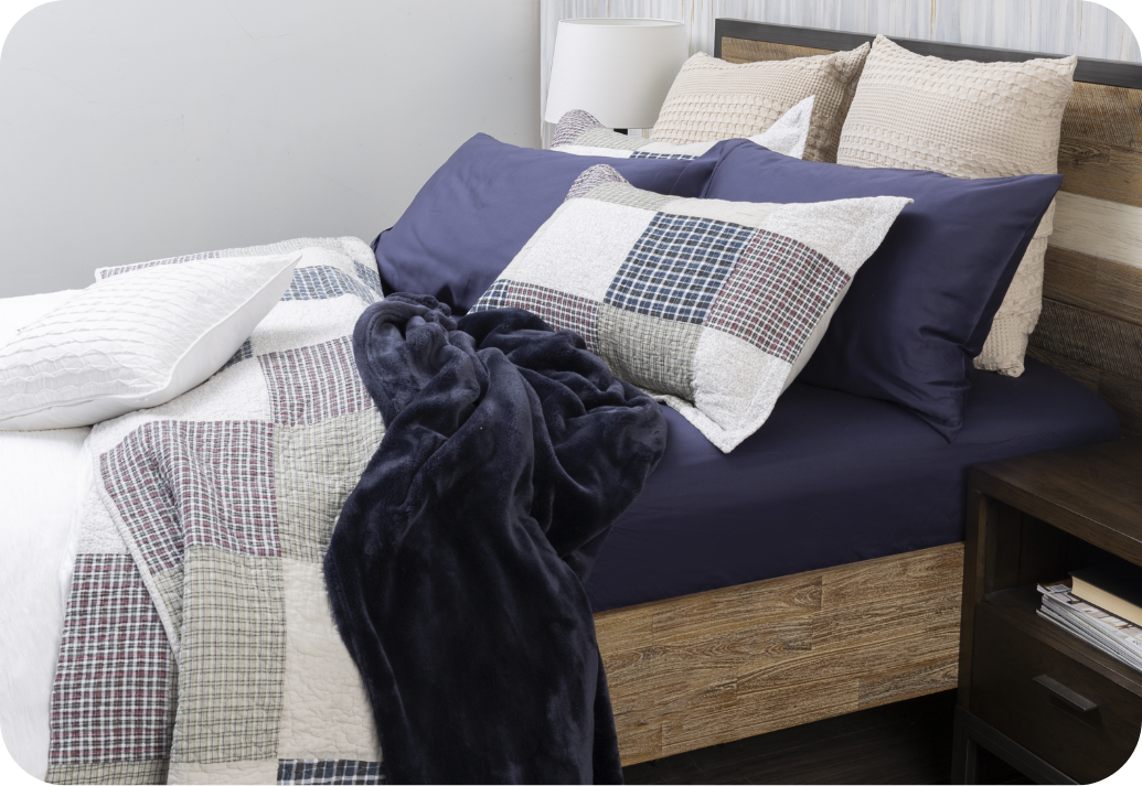 A QE Home quilt styled under a duvet cover.