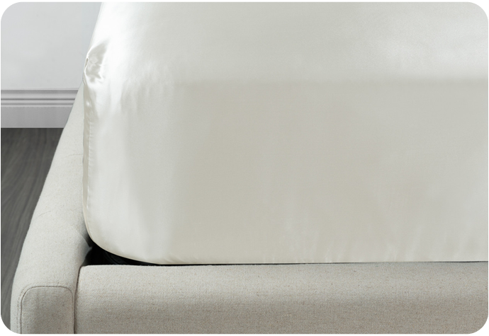 Our Mulberry Silk Fitted Sheet in Snow shown on a mattress.