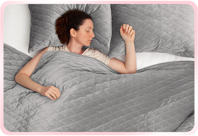 Our grey Calme Weighted Quilt Set is pictured with a woman sleeping.