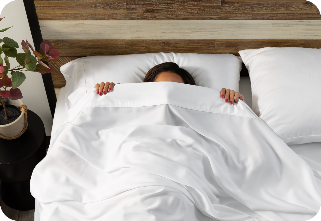 Woman hiding under a white flat sheet.