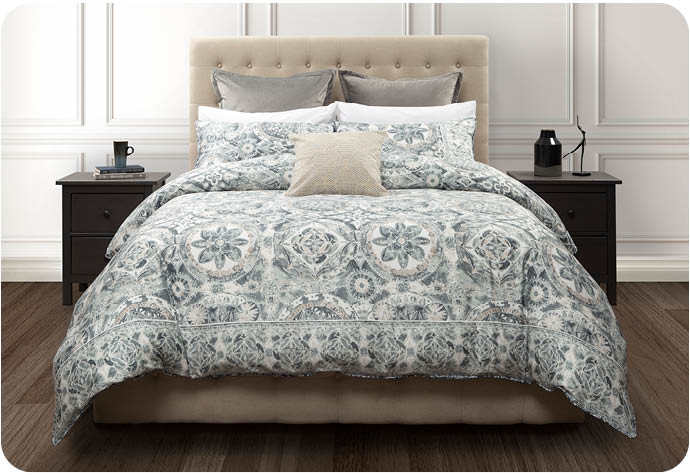 Our blue patterned Sonesta Bedding Collection styled in a luxurious bedroom setting with a decorative square cushions and euro pillows.