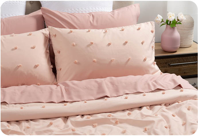 Our pink Blush Dot Recycled Polyester Comforter Set styled on a bed with white Euro Pillow Shams.