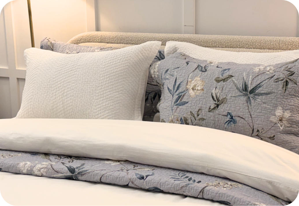 Quilt shams styled at the head of a bed.